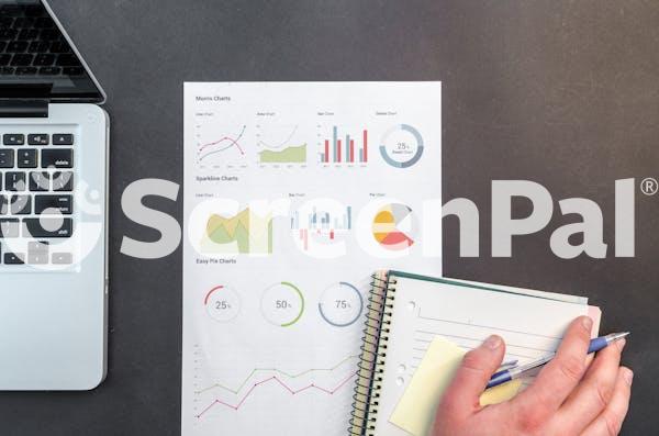 Person Holding Blue Ballpoint Pen On White Notebook